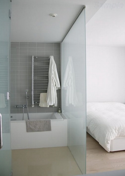 Glass partition separates the sitting area and the bathroom