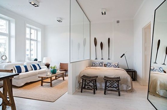 Glass partitions separate the sleeping space from other areas of the studio apartment